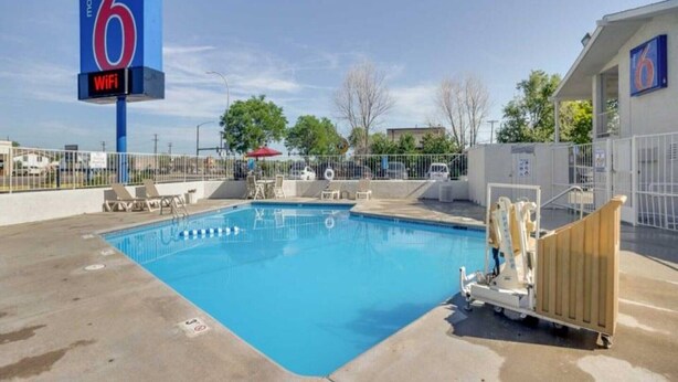 Un motel avec une piscine, un panneau indiquant le numéro 6 et un autre panneau indiquant la présence d’une connexion « WIFI ».