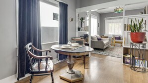 Een woonkamer met een eettafel, een bank en een boekenkast.