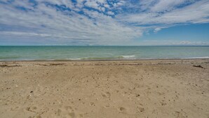 Ein Strand mit blauem Himmel und ruhiger See.