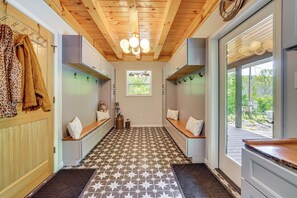 A hallway with a patterned floor, wooden ceiling beams, and a window with a view of greenery. - 'The Appalachian Hideaway' w/ Hiking Trails & Deck (Spencer)