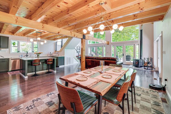 A spacious kitchen with a central island, a dining area with a wooden table and chairs, and a cozy seating area with a fireplace. - 'The Appalachian Hideaway' w/ Hiking Trails & Deck (Spencer)