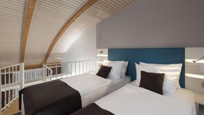 Ein Zimmer mit zwei Betten, einer gewölbten Decke und einem weißen Geländer.