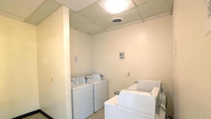 A laundry room with two washing machines and a dryer. - 1 King Bed | Smoking, Kitchen, Sofa-Bed (Longview)