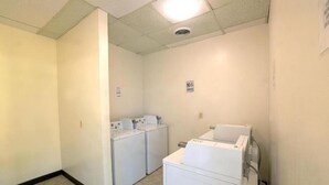 A laundry room with two washing machines and a dryer.