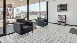 A hotel lobby with two armchairs, a coffee table, a TV mounted on the wall, and a magazine rack. - 2 Queen Beds | Non-Smoking, Micfridge (Longview)