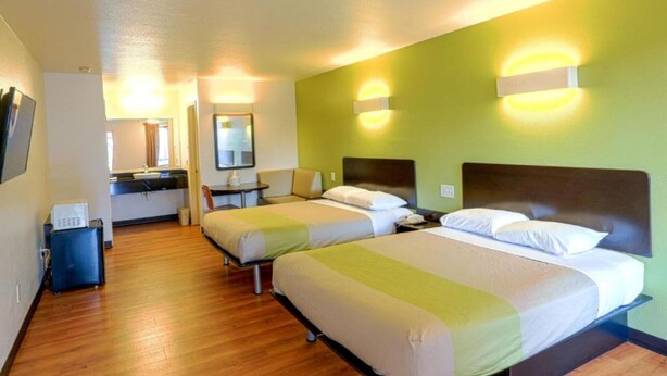 A hotel room with two beds, a desk, a chair, a mirror, and a small kitchenette. - 2 Queen Beds | Non-Smoking, Micfridge (Longview)
