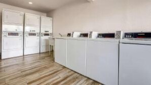 A modern kitchen with white cabinets and a wooden floor. - 1 King Bed|Non-Smoking (Ukiah)