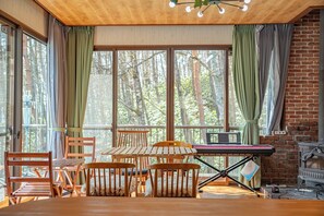 Una habitación con una mesa de madera, sillas, un piano y una chimenea.