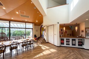 A spacious dining area with a wooden ceiling, large windows, and a view of the outdoors. - Enjoy your time with friends in our wellequipped  / Ito City Shizuoka (Ito City)
