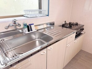 Kylskåp, mikrovågsugn, spishäll och grytor/köksredskap