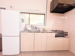Eine kleine Küche mit Kühlschrank, Herd und Spüle.
