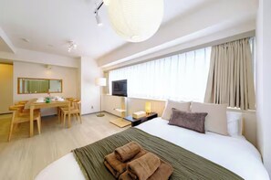 Ein Hotelzimmer mit Bett, Schreibtisch, Stuhl, Fernseher und einem fenster mit Vorhängen.