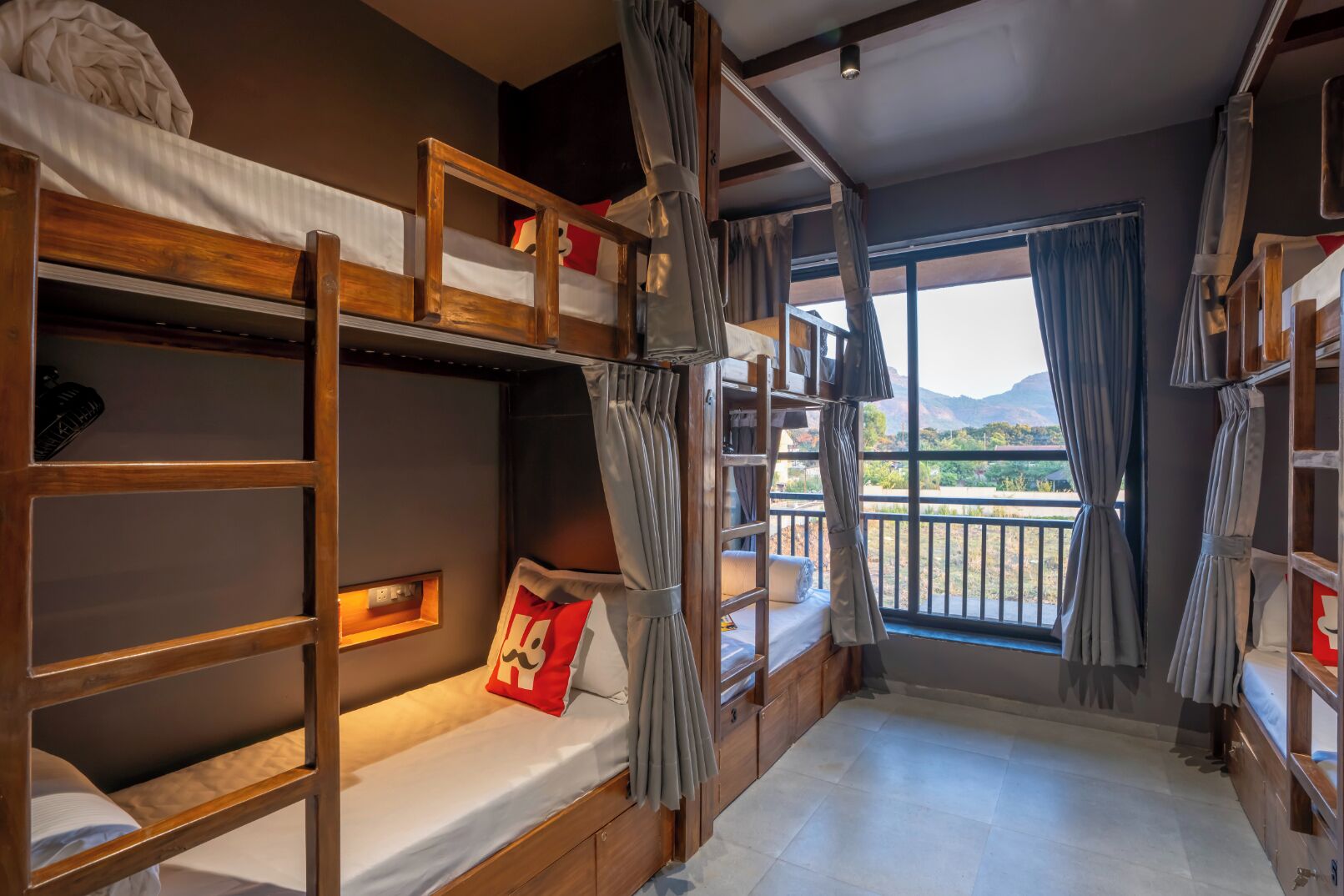 Een slaapkamer met stapelbedden en uitzicht op de bergen.