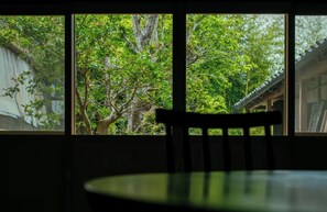 A room with a window overlooking a tree and a traditional building.