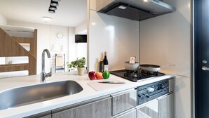 Una cocina moderna con un lavamanos de acero inoxidable, una estufa a gas y un horno empotrado.