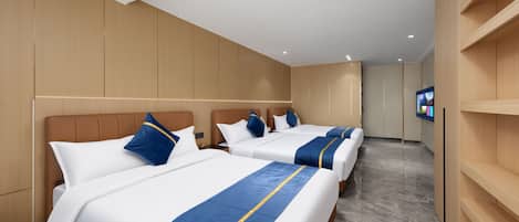 A hotel room with three beds, wooden paneling, a flat-screen TV, and a marble floor.