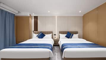 A hotel room with two beds, a nightstand, a mirror, and a window with curtains.