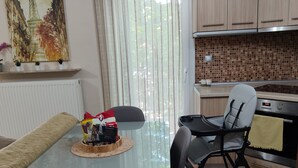 A modern kitchen with a dining table, chairs, a refrigerator, and a microwave.
