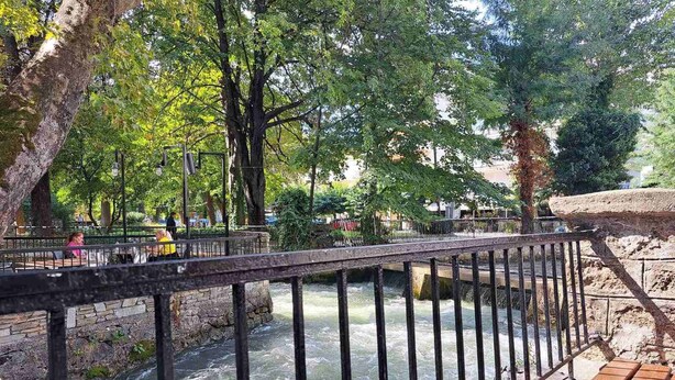 A river with a bridge and a stone wall.