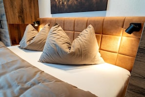 A bed with a headboard, multiple pillows, and a bedside lamp. - Rauris Penthouse with Fireplace (Rauris)
