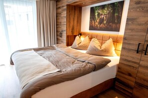 Ein Bett mit Kopfteil, ein Nachttisch und ein an der Wand hängendes Bild.