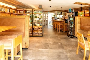 Ein modernes Interieur mit Holzmöbeln, einer Bar und Regalen mit verschiedenen Gegenständen.