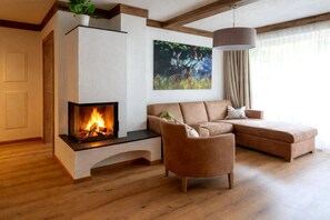 Una sala moderna con chimenea, un sofá seccional, un sillón individual y un cuadro en la pared.