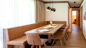 En matplats med ett träbord, bekväma sittbänkar och en hängande lampa.