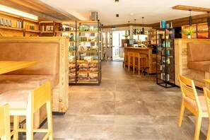 A modern interior with wooden furniture, a bar area, and shelves stocked with various items. - Family Penthouse with Balcony (Rauris)