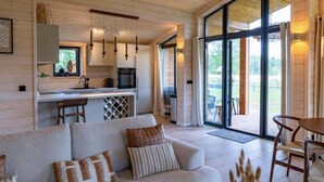 A modern interior with a sofa, dining table, and kitchen area.
