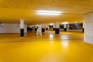 A parking garage with yellow floors and white pillars. - Rauris Suite with Breakfast & Sauna (Rauris)