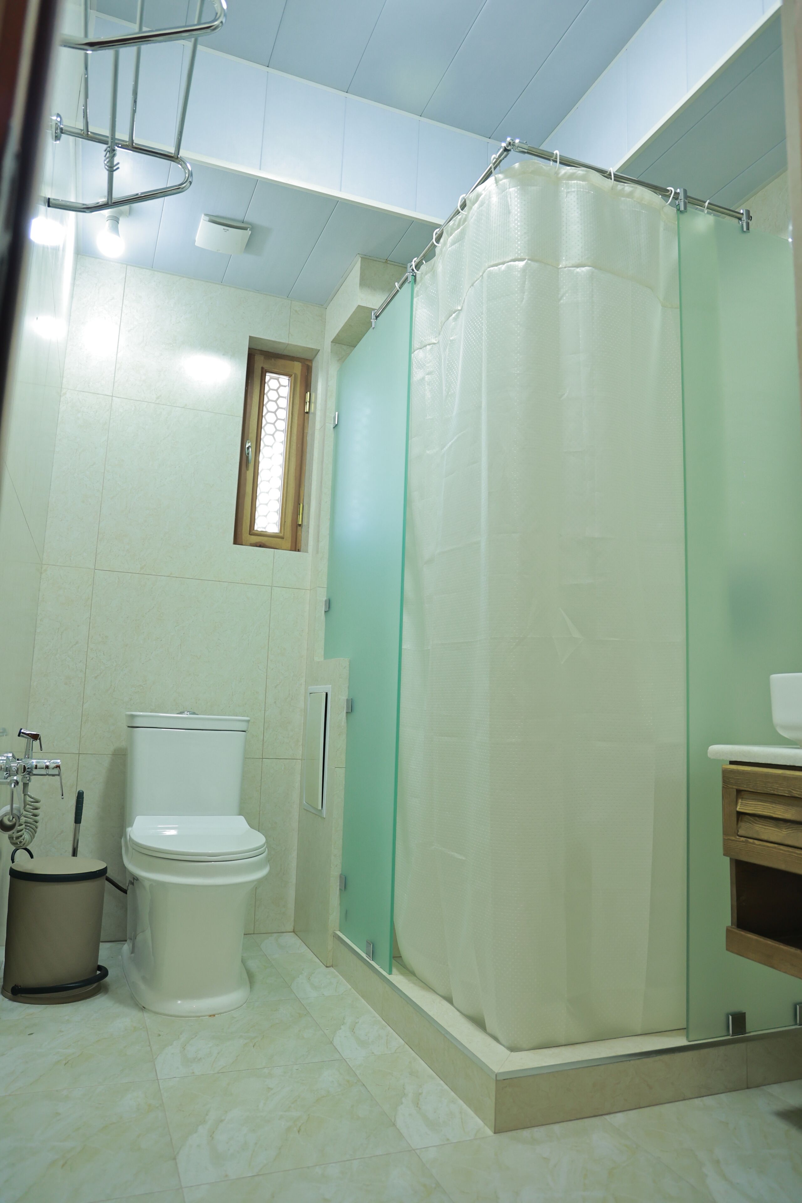 Un baño con inodoro, cabina de ducha de cristal y lavabo.