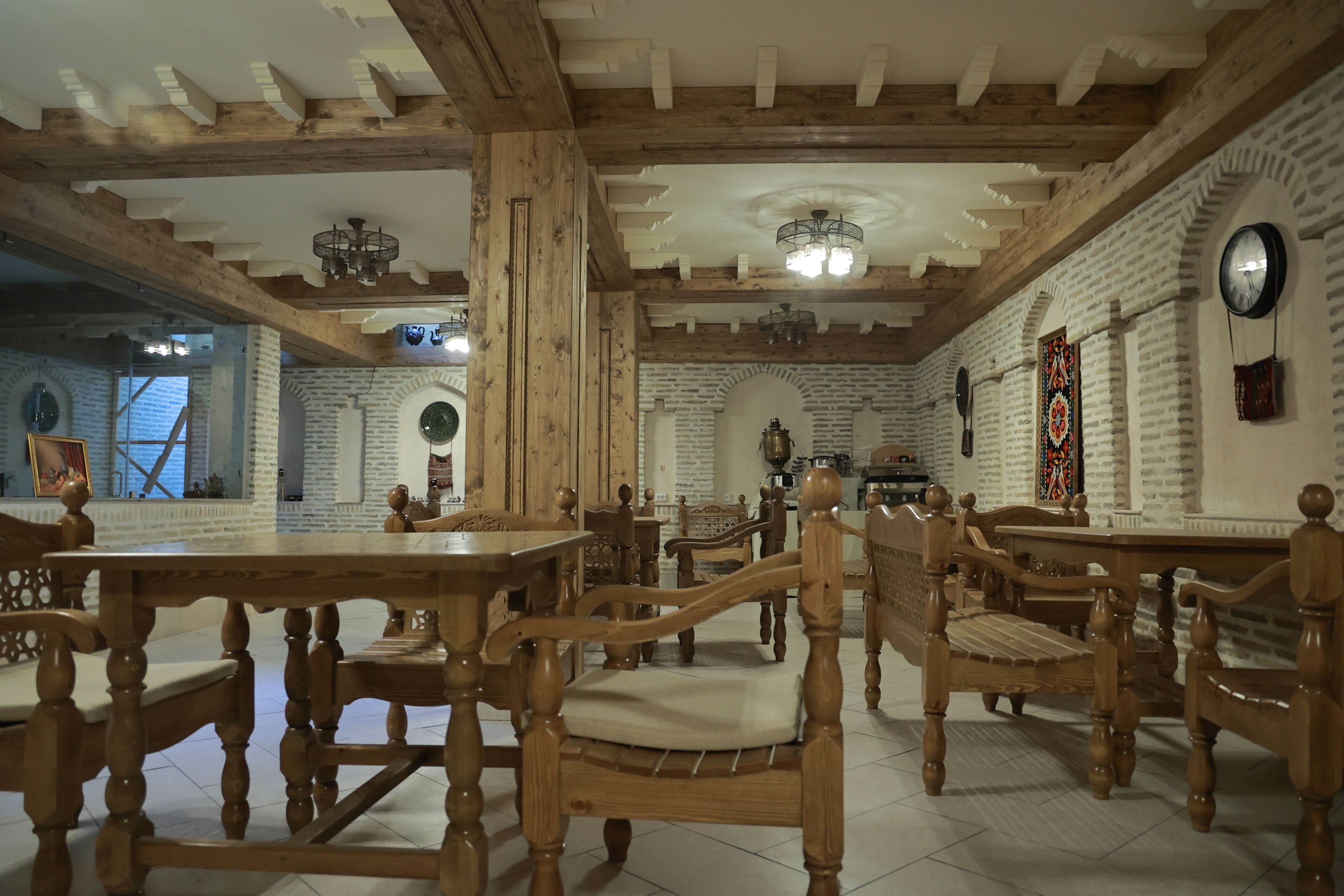 A dining area with wooden furniture, brick walls, and a chandelier.
