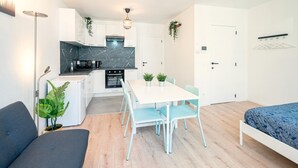 A compact living space with a kitchenette, dining area, and a bed.