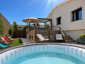 An outdoor swimming pool with a wooden deck, lounge chairs, and a covered seating area. - Cozy Villa with Spa - Beach Within Walking Distance - Gujan-La Hume (Gujan-Mestras)