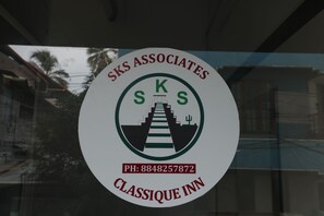A circular logo with the text 'SKS Associates' and 'CLASSIQUE INN' along with a phone number. - Classique Inn | Near Padmanabhaswamy Temple (Thiruvananthapuram)