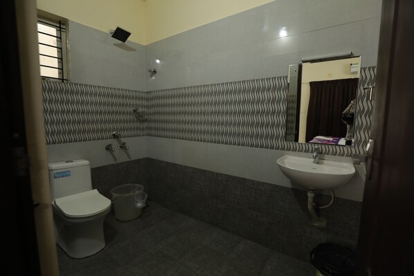 Une salle de bain avec des toilettes, un lavabo et une douche.