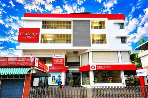 A building with a Classic Inn sign, a Diabetes Centre, and KimsHealth Medical Centre. - Classique Inn | Near Padmanabhaswamy Temple (Thiruvananthapuram)