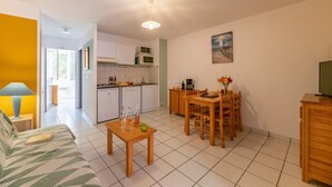 Een knus verblijf met een kitchenette, een eethoek en een slaapbank.