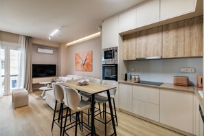 Un appartement moderne comprenant un coin repas, une cuisine et un salon.