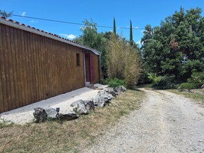 Ein Holzhaus mit einem Kiesweg, der zu einer roter Tür führt.