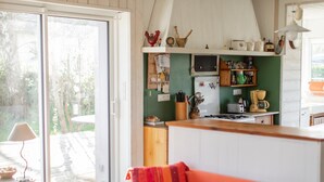 Una cucina con frigorifero, fornello e diversi utensili.