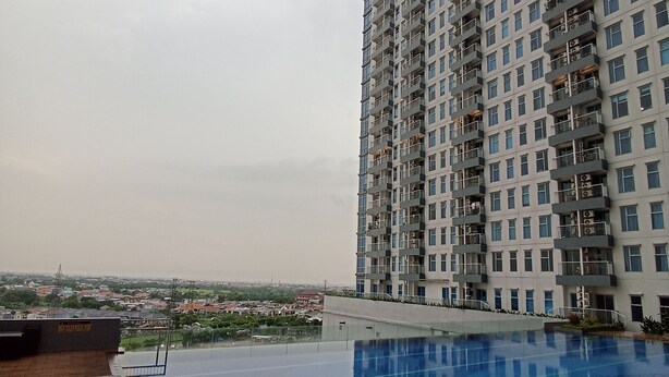 Un edificio alto con una piscina al frente.
