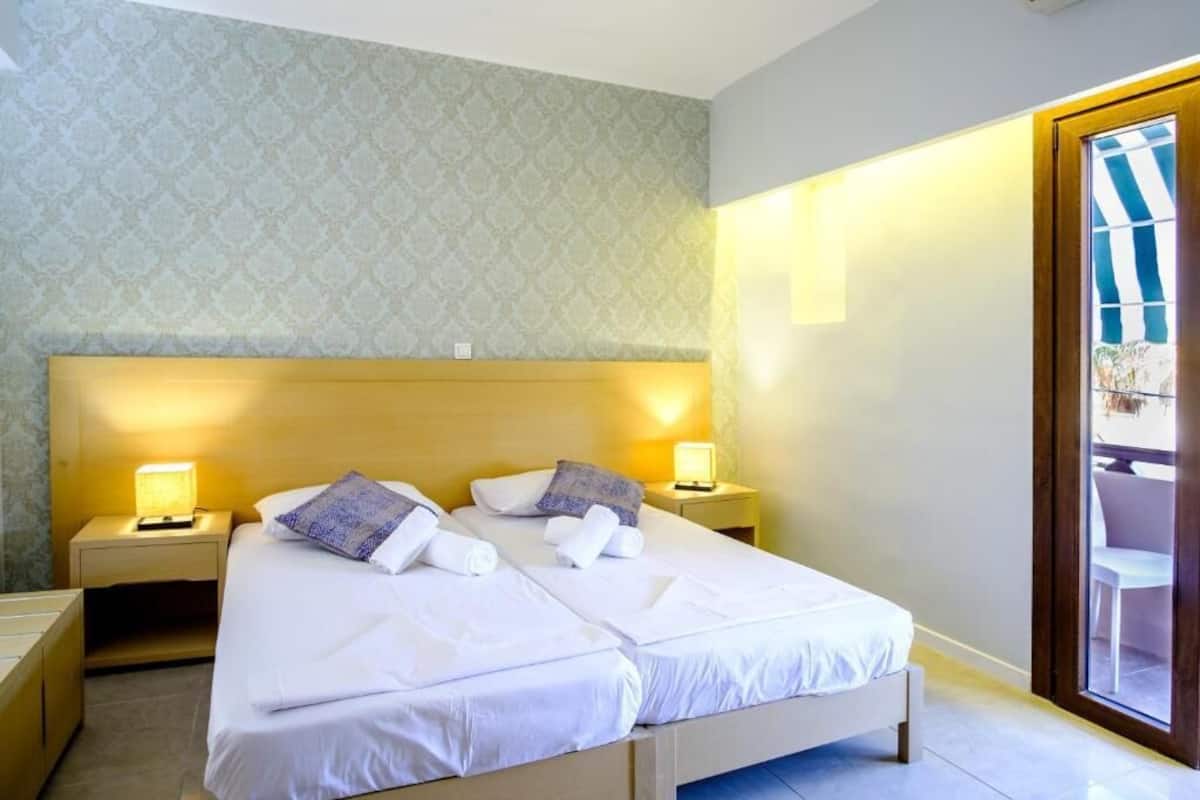 A double bed with two bedside tables, a headboard, and a window with a view.