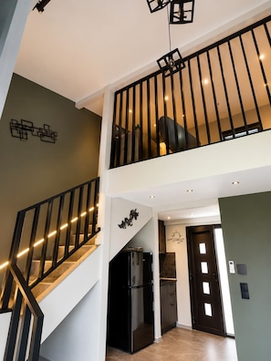 Un intérieur moderne comprenant un escalier, un coin cuisine et un espace repas.
