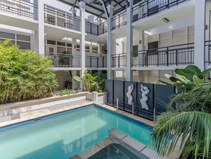 A multi-level hotel with a swimming pool, balconies, and indoor plants. - Coastal Luxe Rooftop Escape - Paradiso 345 (Tweed)