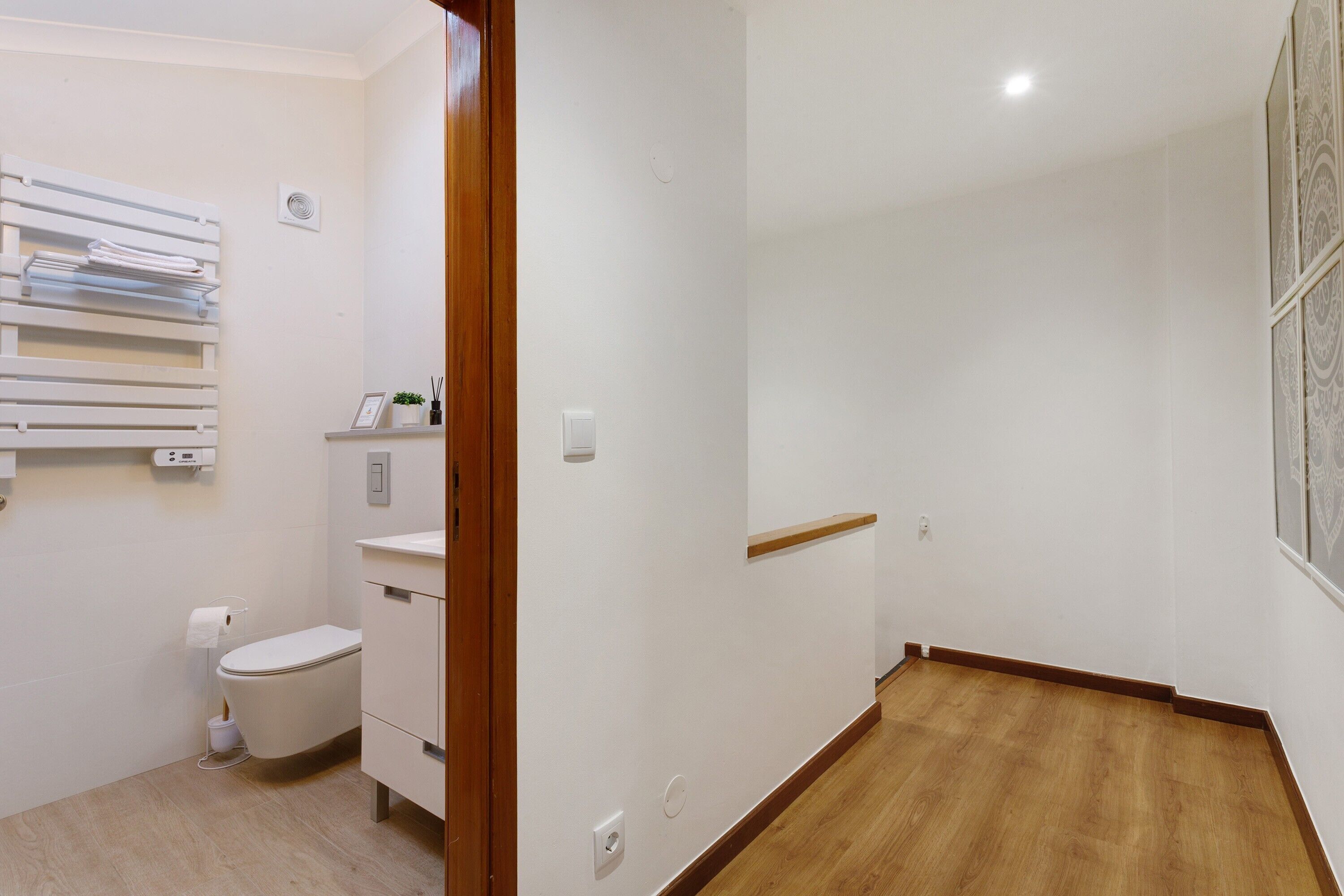 Un bagno con il water, un lavandino, uno specchio e un porta asciugamani.