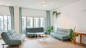 Ein modernes Wohnzimmer mit einer Couch, zwei runden Tischen und einem Couchtisch.