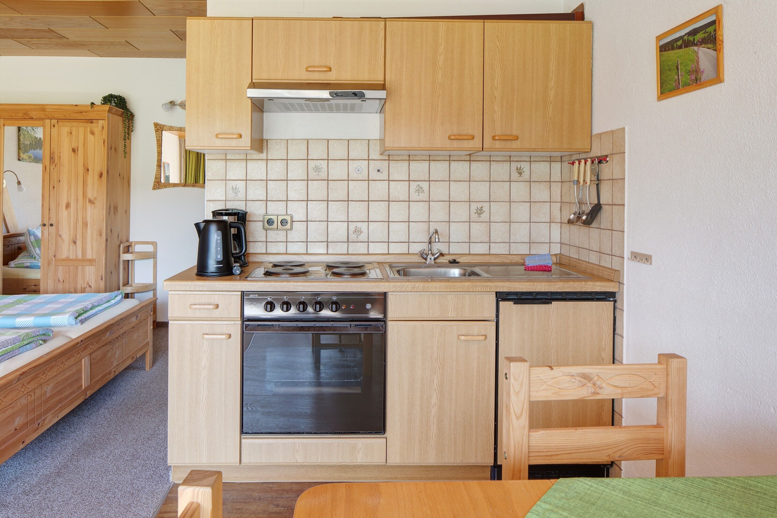 Una cocina compacta con armarios de madera, estufa, fregadero y lavavajillas.