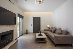 A modern living room with a flat-screen TV, a fireplace, a sofa, and a coffee table. - Escape to Casadi Fileri Villa, a brand-new property in the area of Ialysos. (Rhodes)